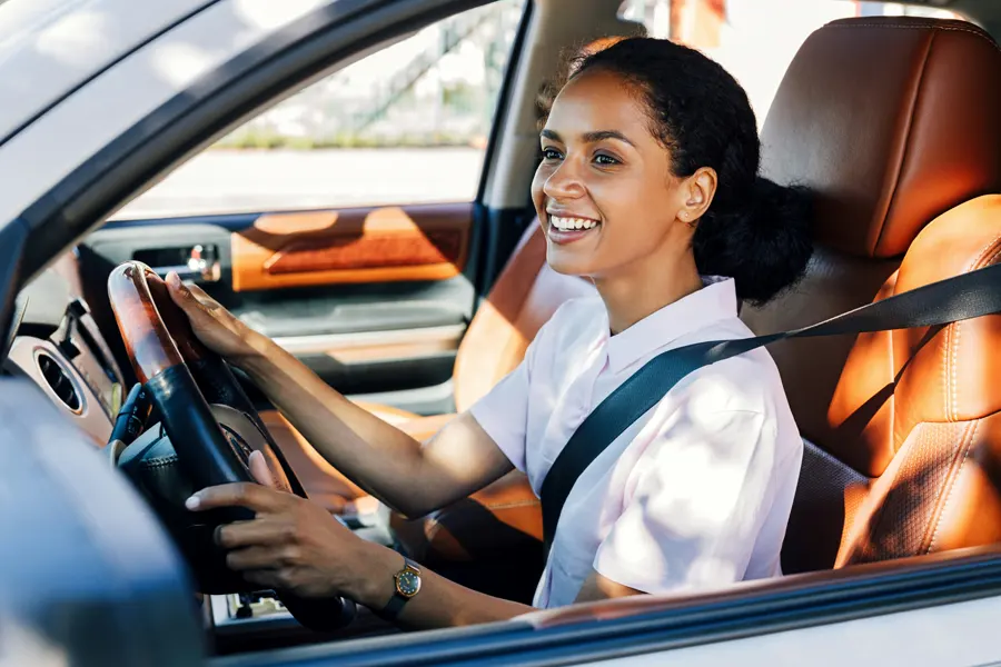 Young woman in car smiling